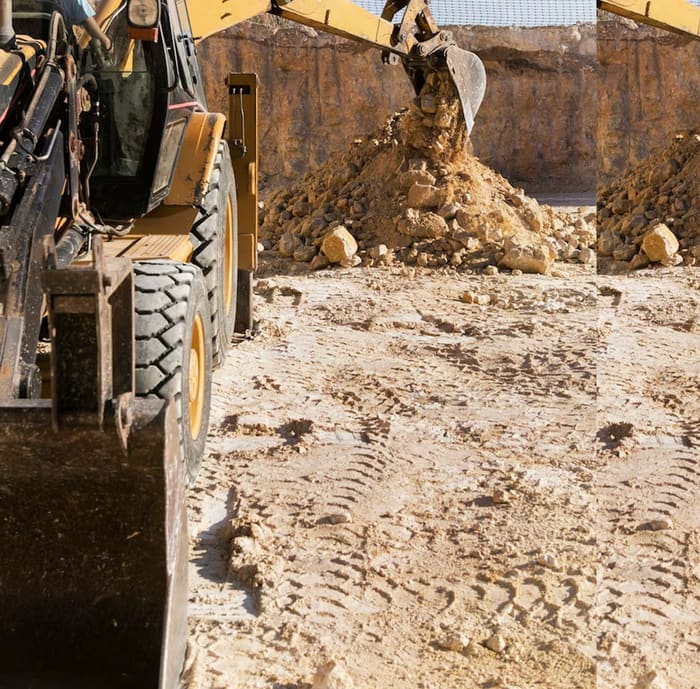 Backhoe loading sand and gravel at the riverbed extraction site