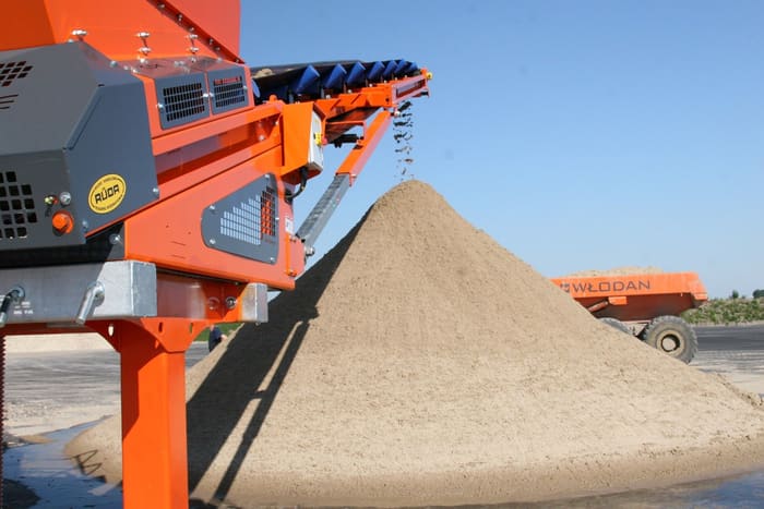 Washed sand stockpiled beneath a screening-plant conveyor